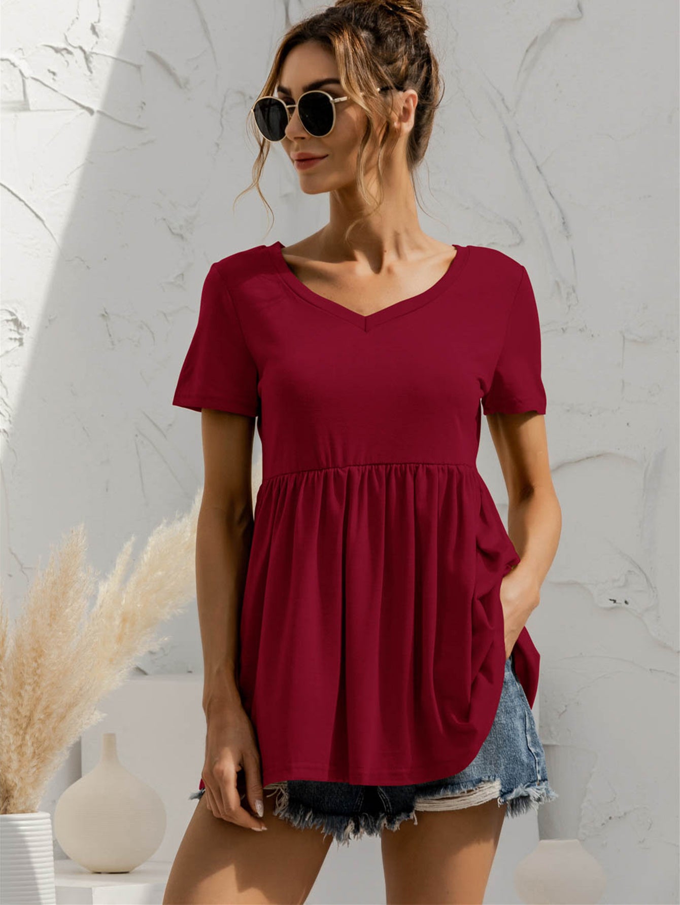 Burgundy v-neck tee with gathered waistline and short sleeves.