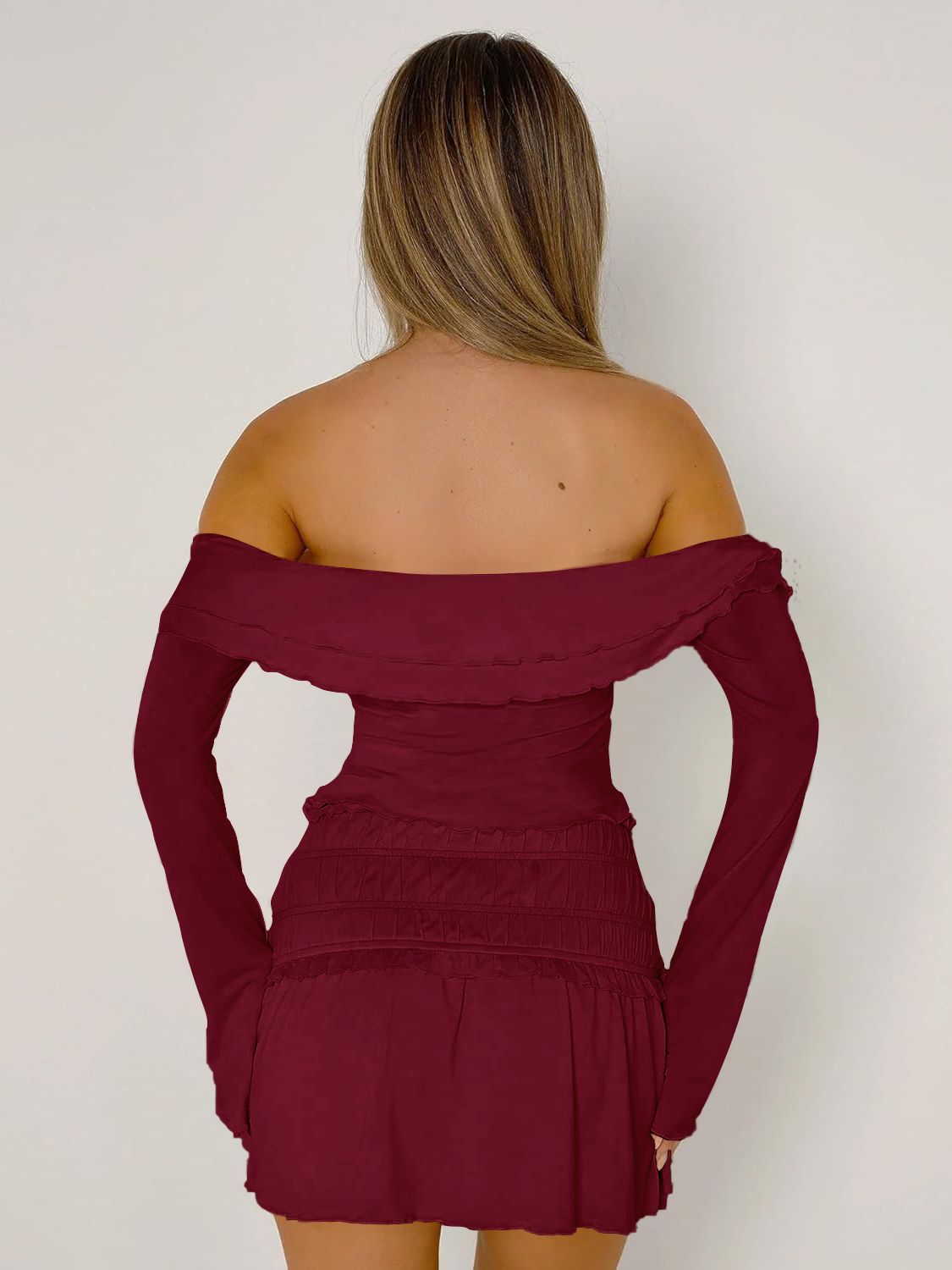 Ruched bodice off-shoulder top in rust with long sleeves and ruffled neckline.