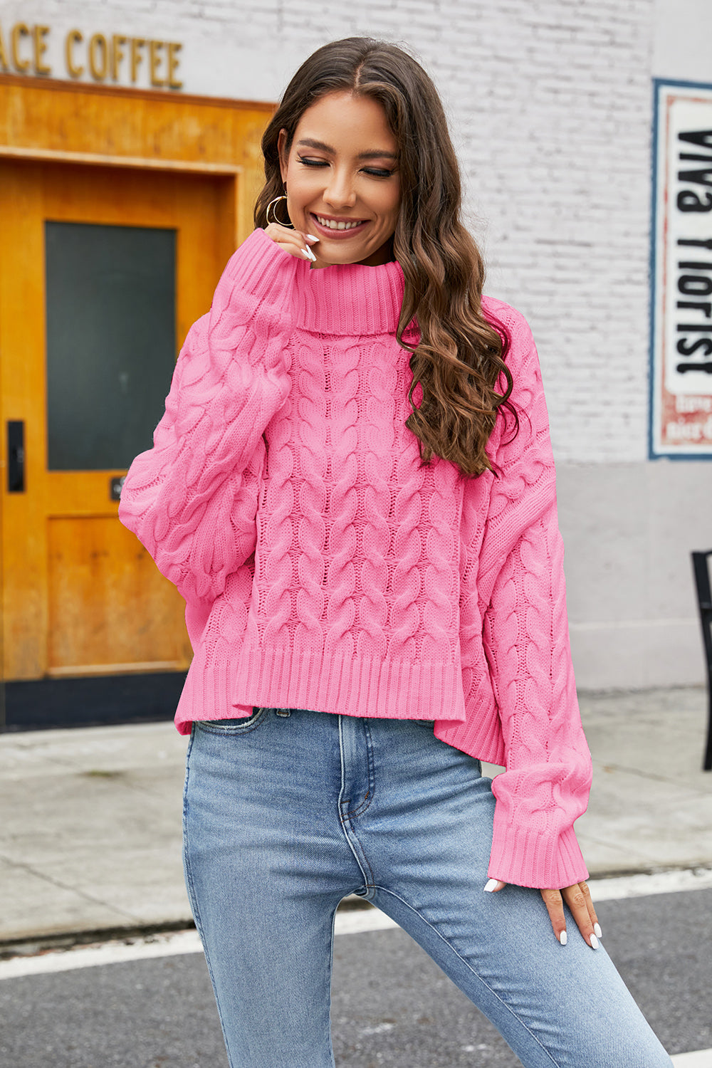 Cropped cable knit turtleneck sweater in hot pink acrylic with a high neck.
