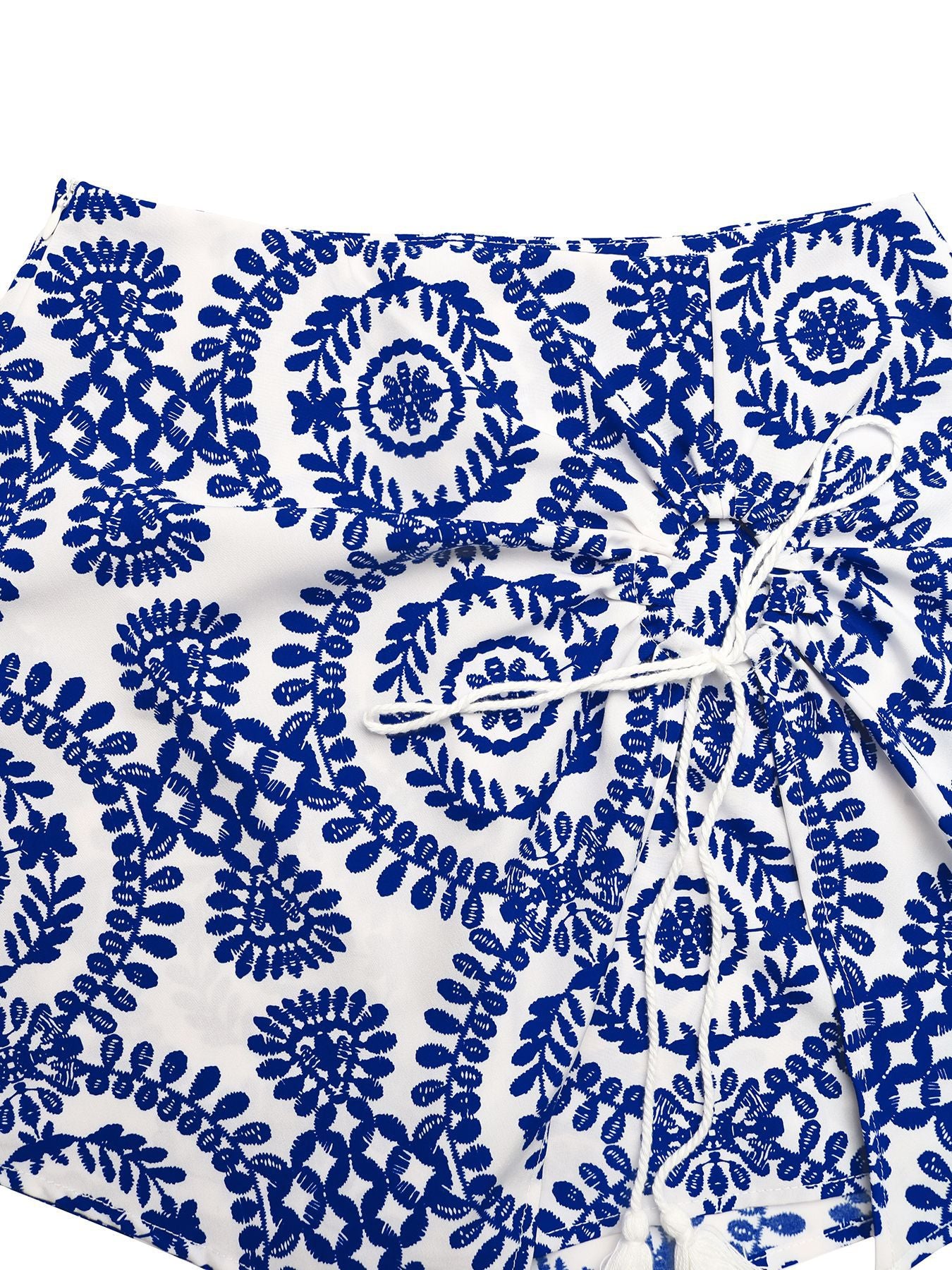 Floral tie skort with drawstring and tassels, blue embroidery on white fabric.