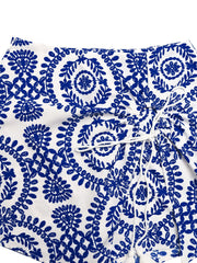 Floral tie skort with drawstring and tassels, blue embroidery on white fabric.