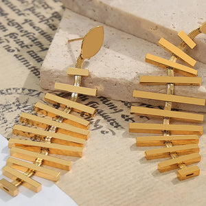 Gold geometric steel fishbone drop earrings with a modern design.
