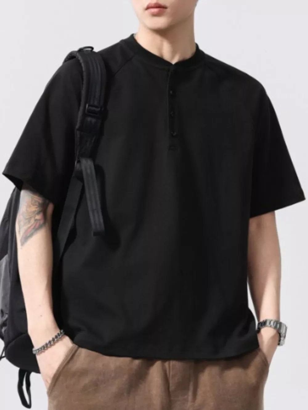 Black buttoned henley t-shirt for men with short sleeves and a band collar.