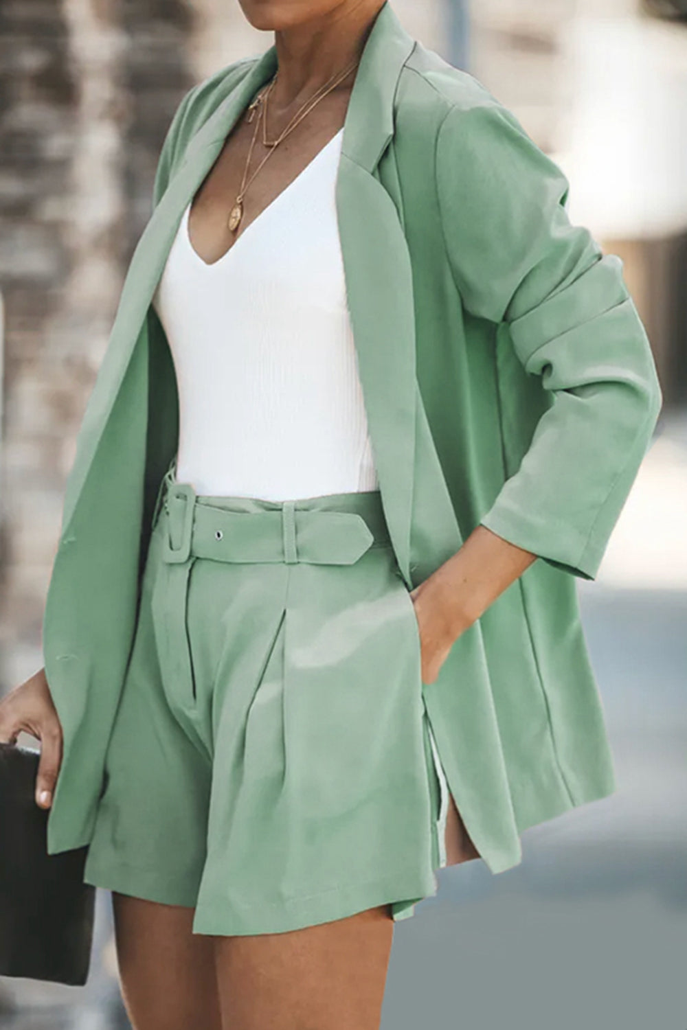 Gum Leaf double-breasted blazer and belted pleated shorts set with a white V-neck top.