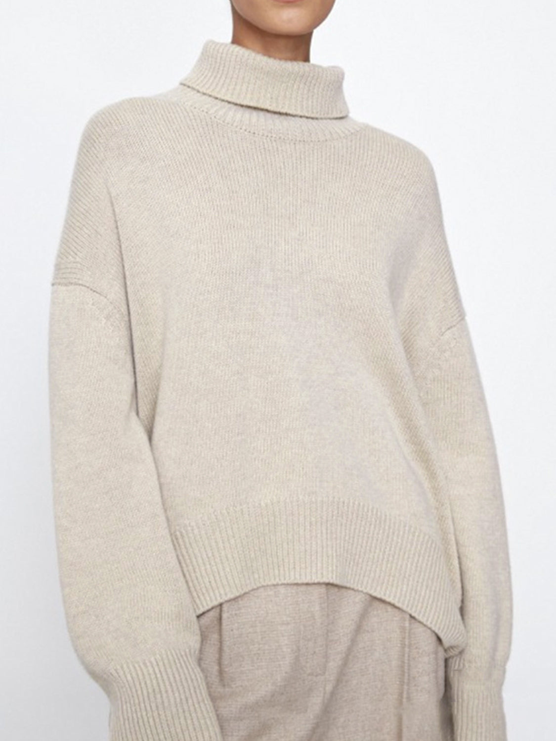 Relaxed turtleneck sweater in Ivory with sculptural sleeves and ribbed trim.