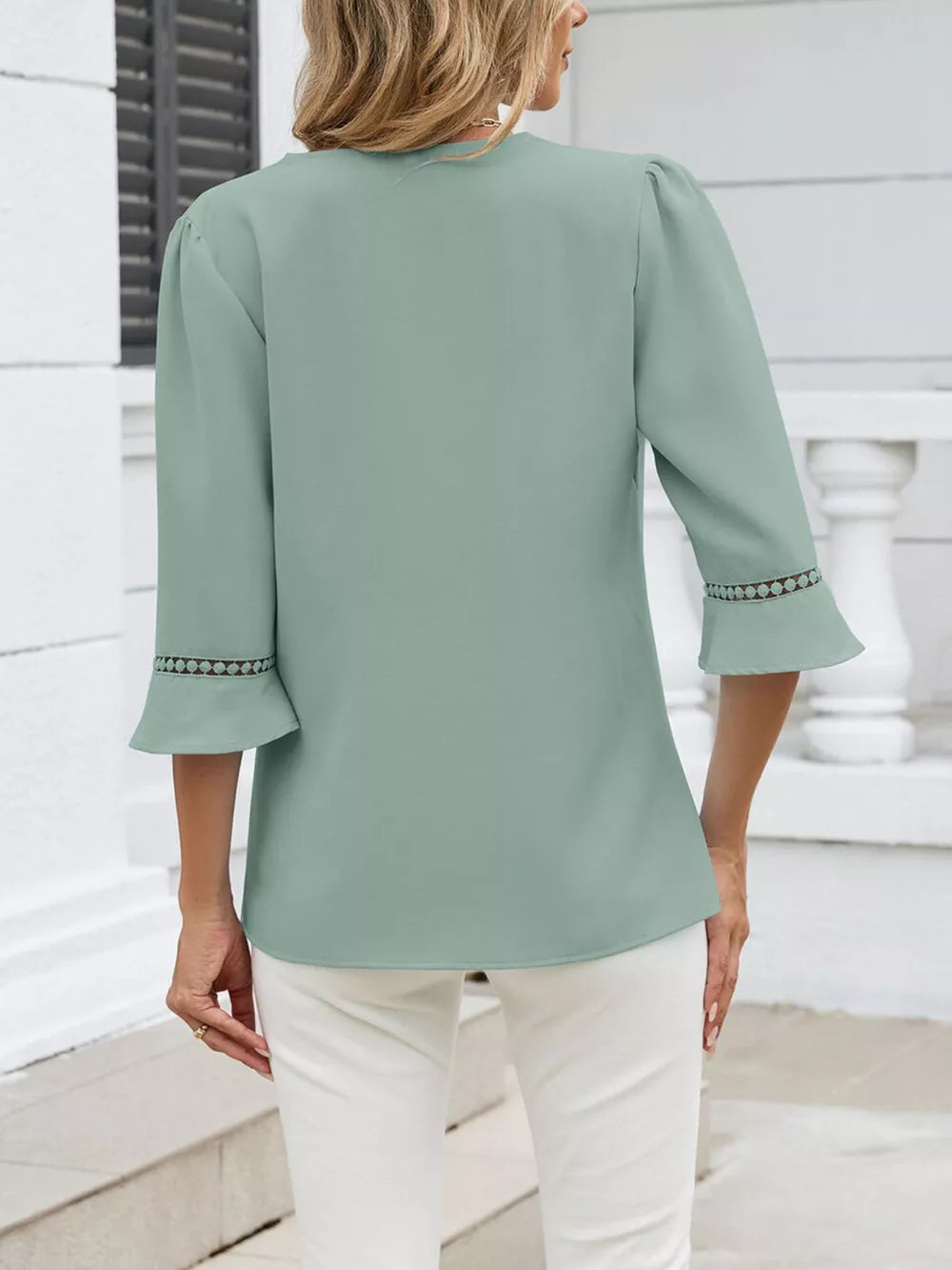 Bean green blouse with 3/4 sleeves featuring lace trim on the cuffs and subtle puff shoulders.