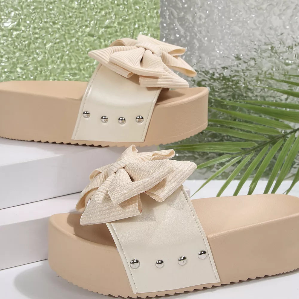 Ribbed bow accent platform sandals in white with beige sole and silver studs.