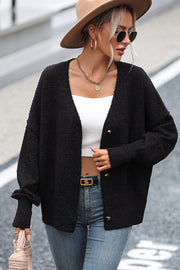 Black textured bouclé button-down cardigan with gold buttons, relaxed fit, and v-neck.