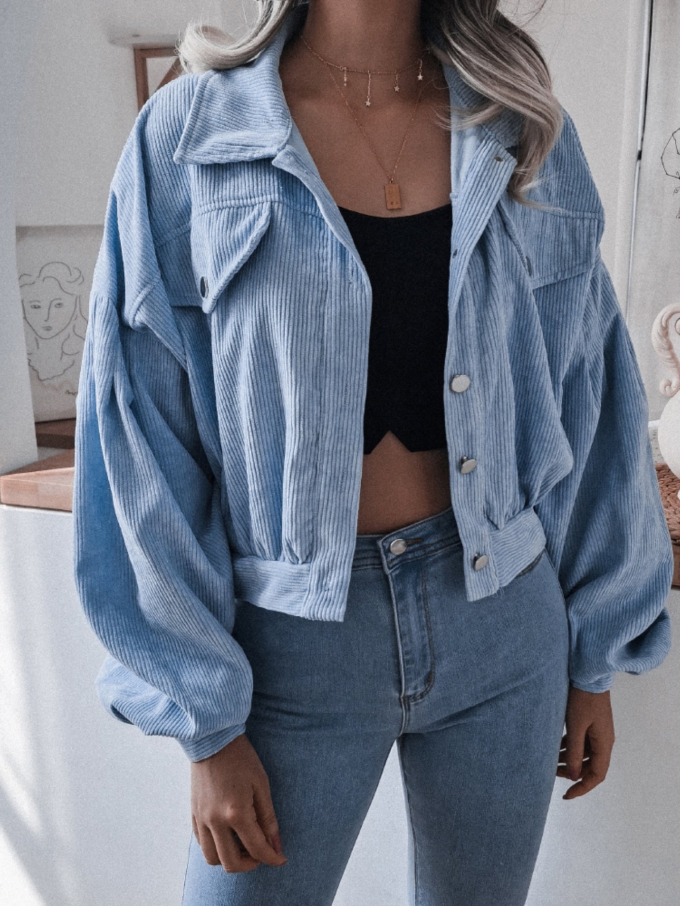 Blue corduroy cropped jacket with balloon sleeves and button-up front.