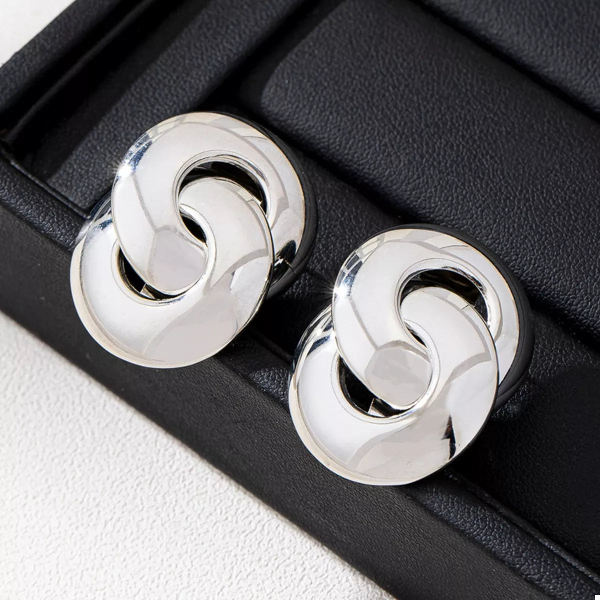 Chunky knot earrings in silver, featuring interlocking circles with a polished finish.