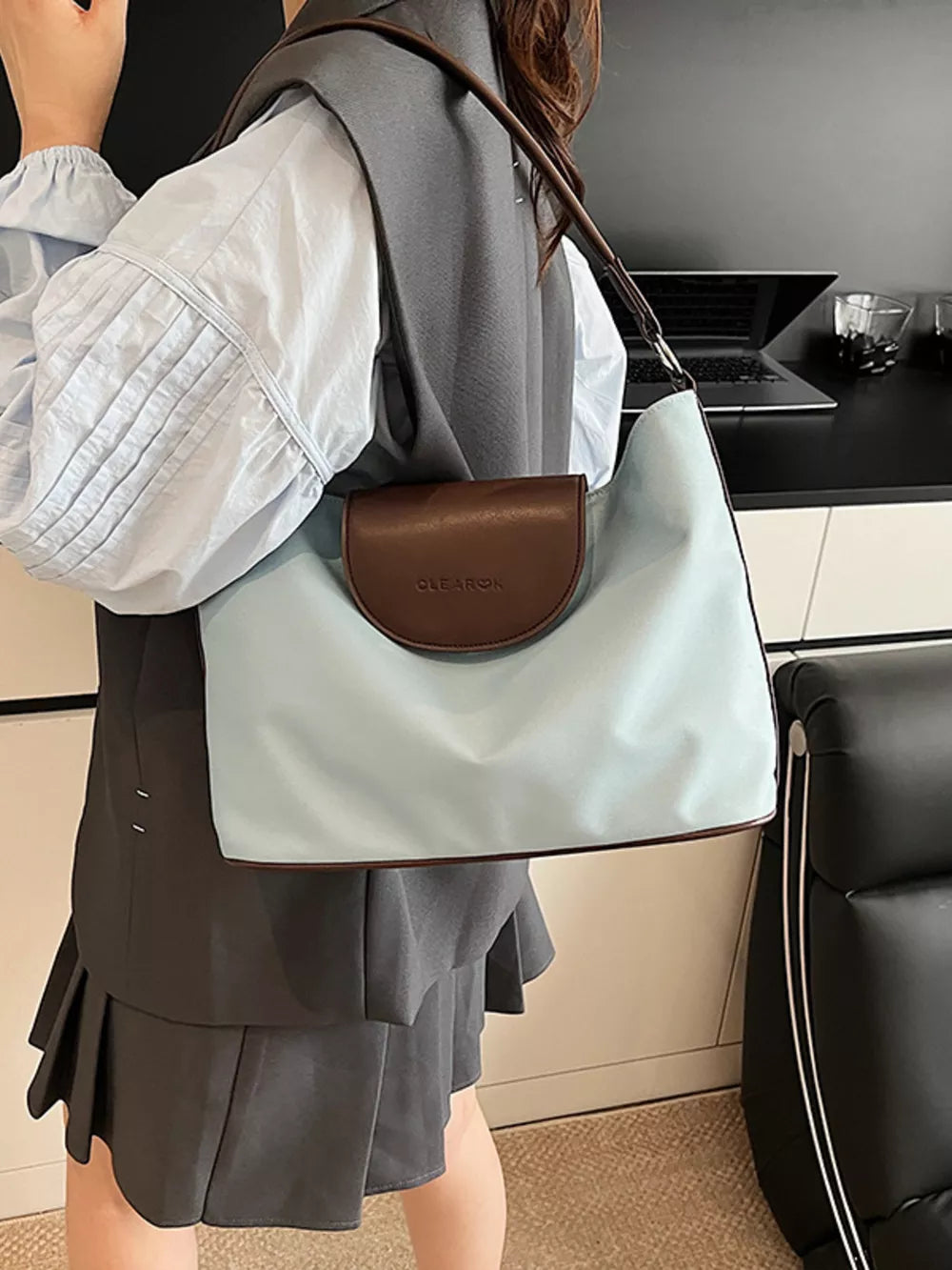 Chic canvas hobo crossbody bag in blue with brown trim and flap detail.
