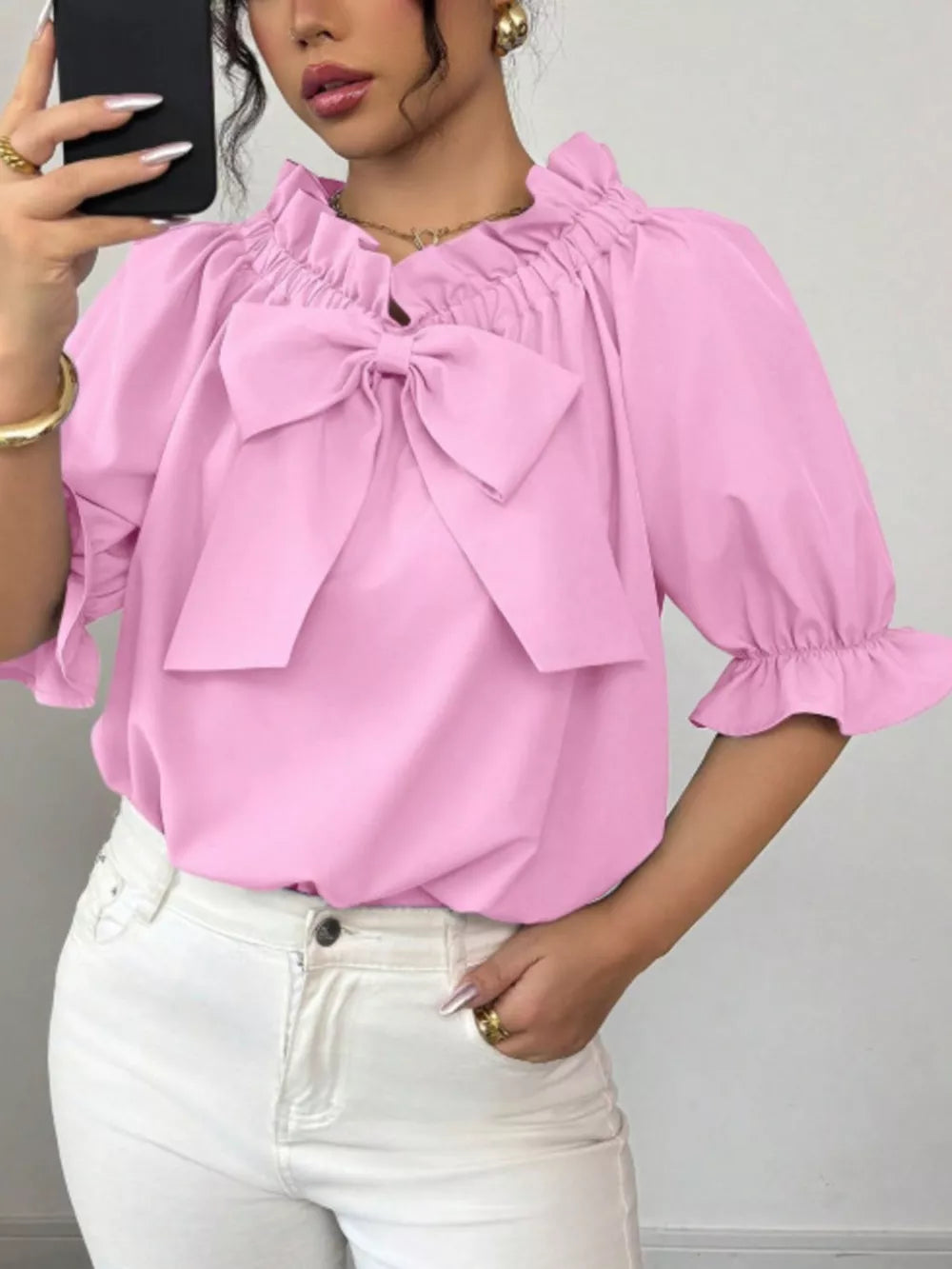 Pink ruffled bow sleeve blouse with cinched neckline and puff sleeves.