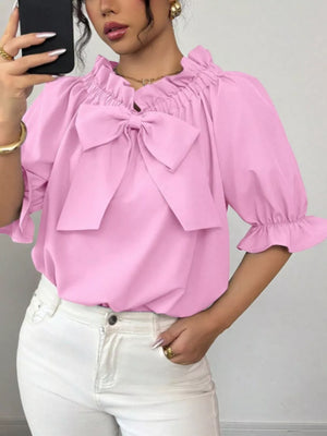 Pink ruffled bow sleeve blouse with cinched neckline and puff sleeves.