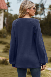 Dark Blue waffle knit raglan v-neck top with textured sleeves.