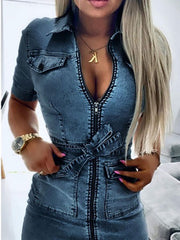 Zipper front denim shirt dress in blue with short sleeves, collar, tie waist, and chest pockets.