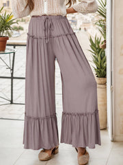 Mauve ruffle edge wide-leg pants with drawstring waist and tiered ruffles.