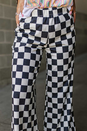Checkerboard palazzo trousers in black and white with a wide leg and elastic waistband.