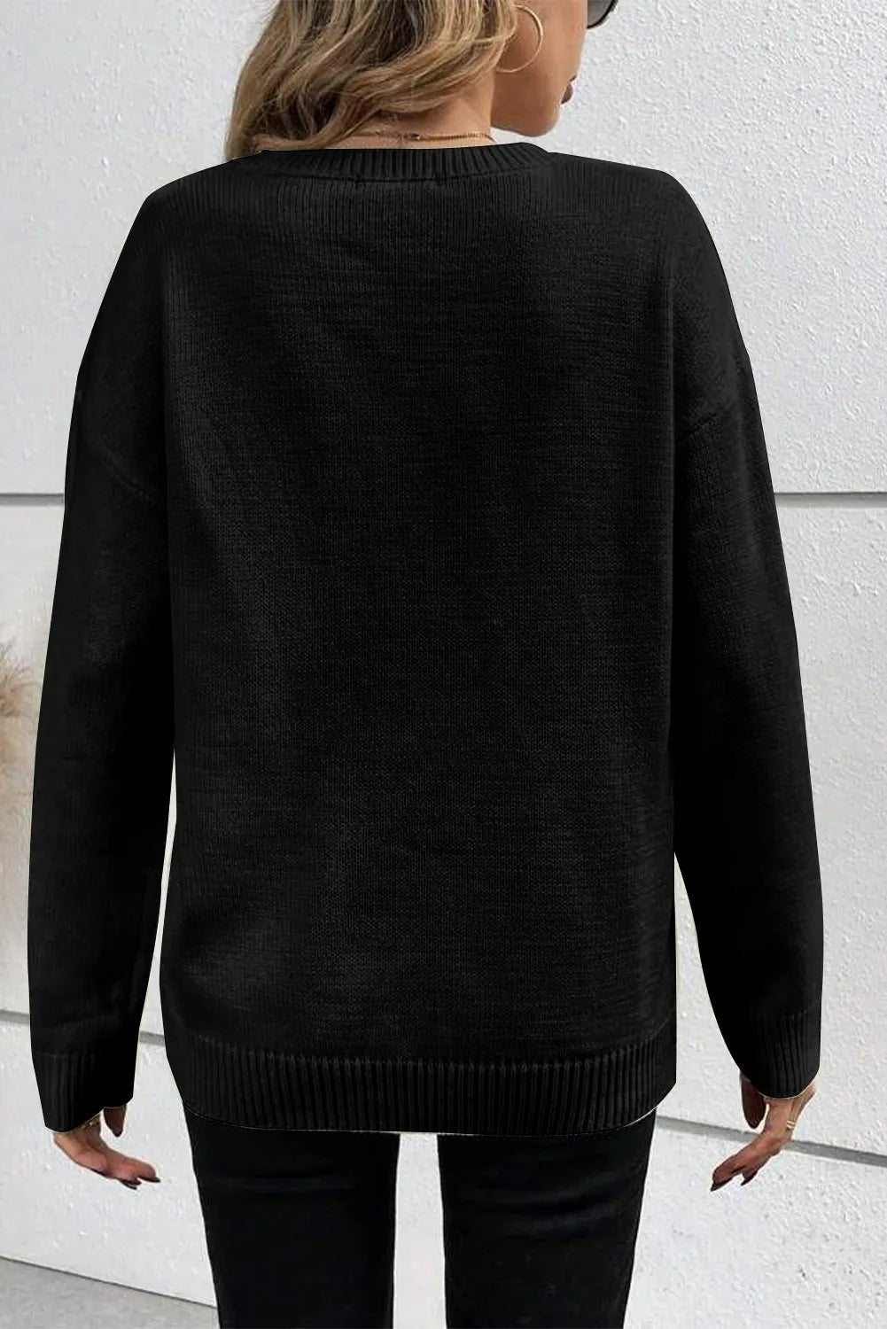 Black crewneck sweater with appliqué detail, long sleeves, and ribbed hem.