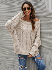 Cable knit off-shoulder sweater in Dust Storm acrylic with slouchy fit and open knit details.