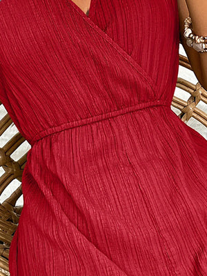 Deep red textured wrap-front romper with elastic waist and V-neck detail.