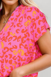 Hot pink leopard print blouse with flutter sleeves and V-neck.
