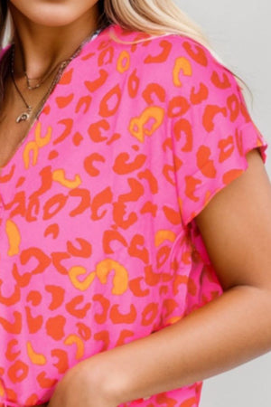 Hot pink leopard print blouse with flutter sleeves and V-neck.