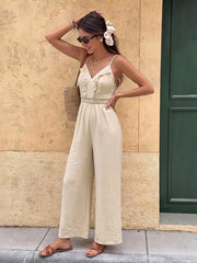 Lace-trimmed spaghetti strap romper in cream with wide legs and V-neck.
