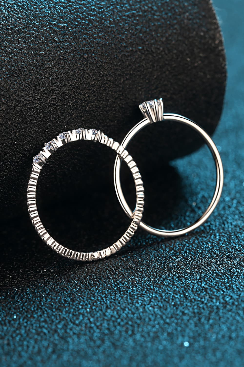 Silver layered ring set with moissanite accents and a solitaire ring.