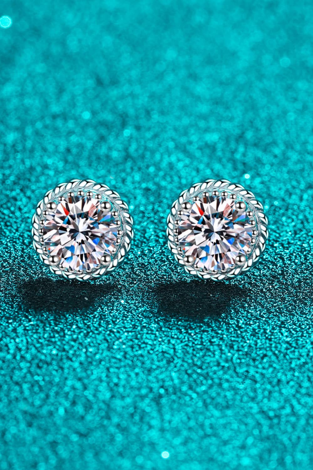 Sterling silver stud earrings with moissanite gems and rope-textured frames.