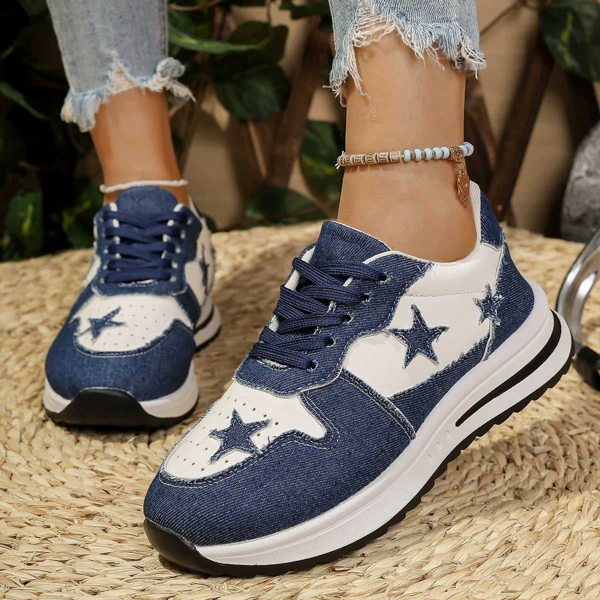 Blue and white denim lace-up sneakers with star embellishments and a chunky sole.