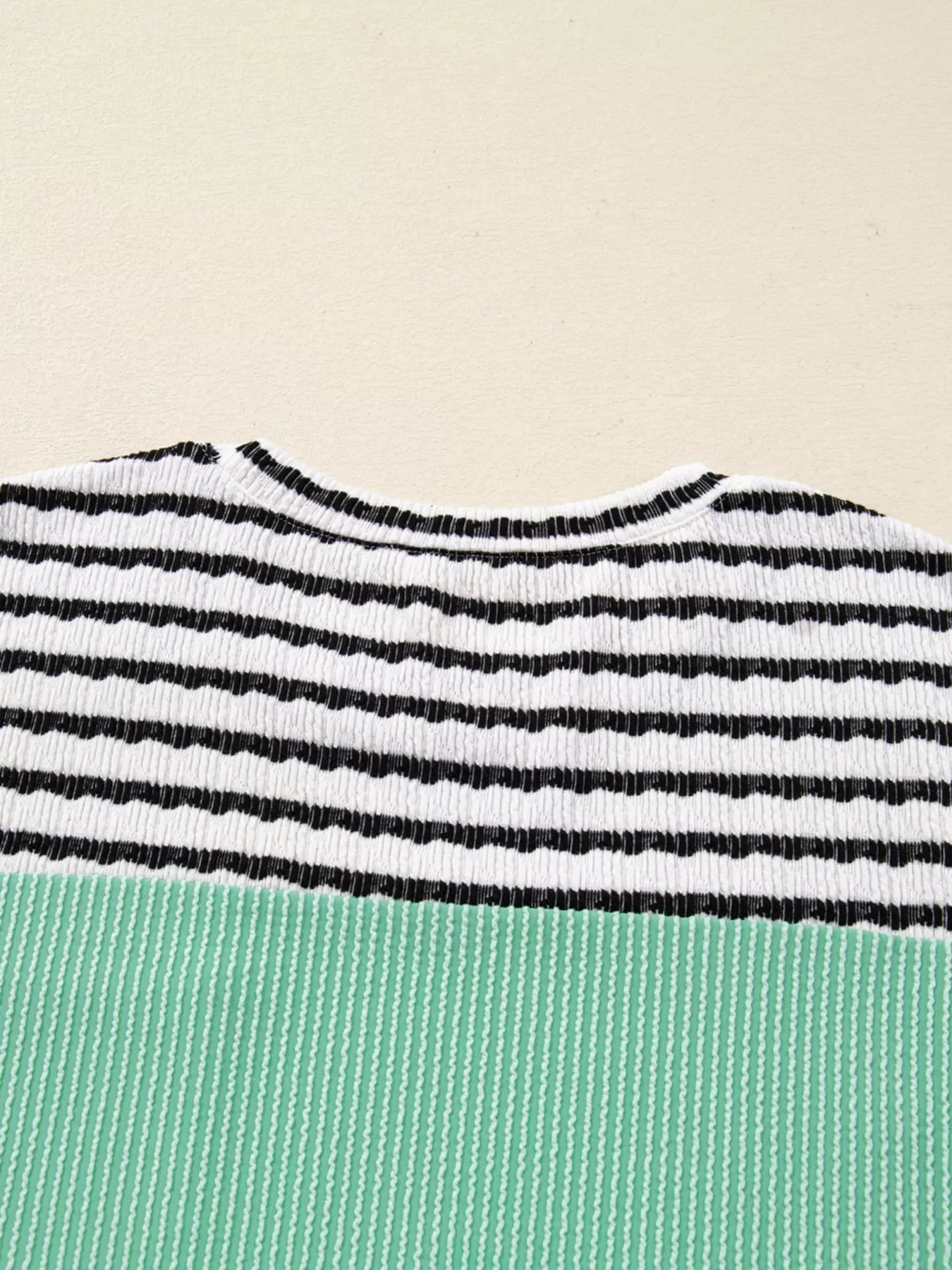Turquoise and black striped ribbed long-sleeve top with a crew neck.