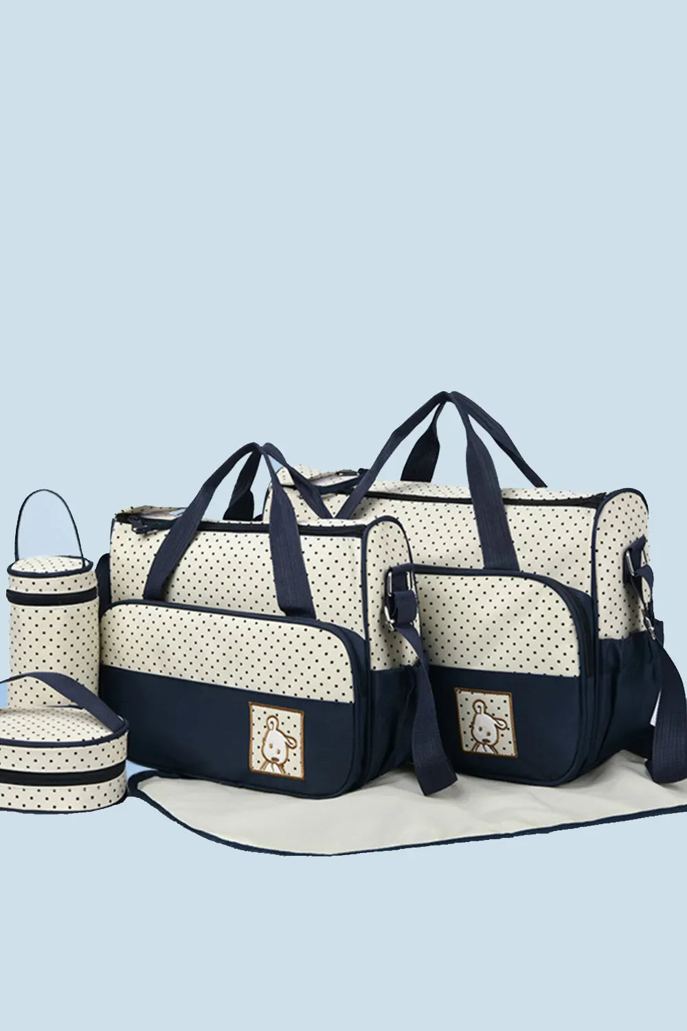 Polka dot diaper bag set in cream and dark navy with embroidered animal detail.