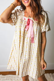Floral mini dress with lace trim, puff sleeves, and pink bow detail on a striped floral print.