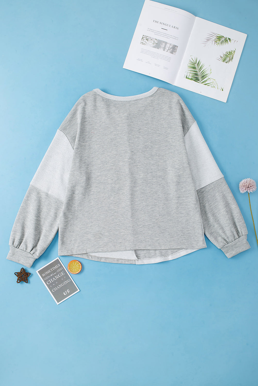 Light gray colorblock sweatshirt with crew neck, long sleeves, and textured paneling.