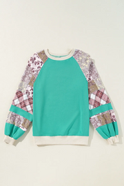 Turquoise raglan sleeve sweatshirt with patchwork plaid and paisley sleeves.