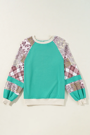 Turquoise raglan sleeve sweatshirt with patchwork plaid and paisley sleeves.
