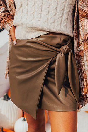 Brown faux leather mini skirt with knot-front detail and wrap style.