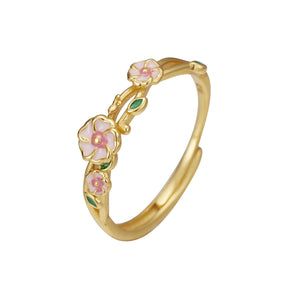 Gold adjustable ring with delicate pink flowers and green leaves.