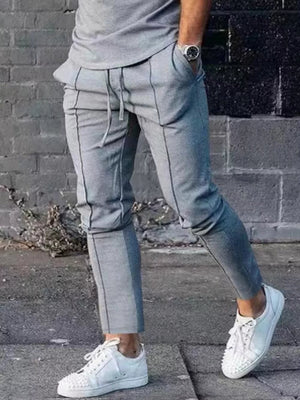 Light gray casual drawstring sweatpants with pockets and contrast panel detail.