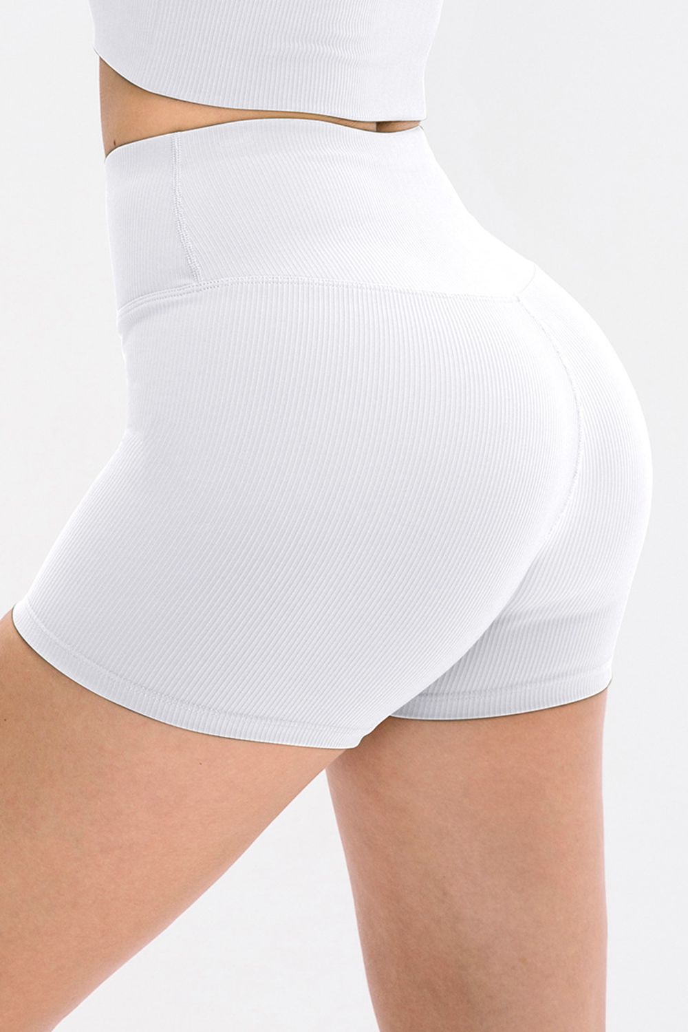 White ribbed sculpting active shorts with a high waist and v-cut detail.