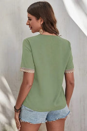 Light green V-neck blouse with lace trim on short sleeves.
