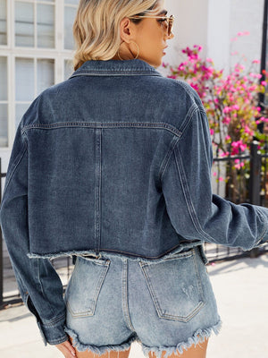 Navy denim trucker jacket with raw hem and buttoned cuffs.