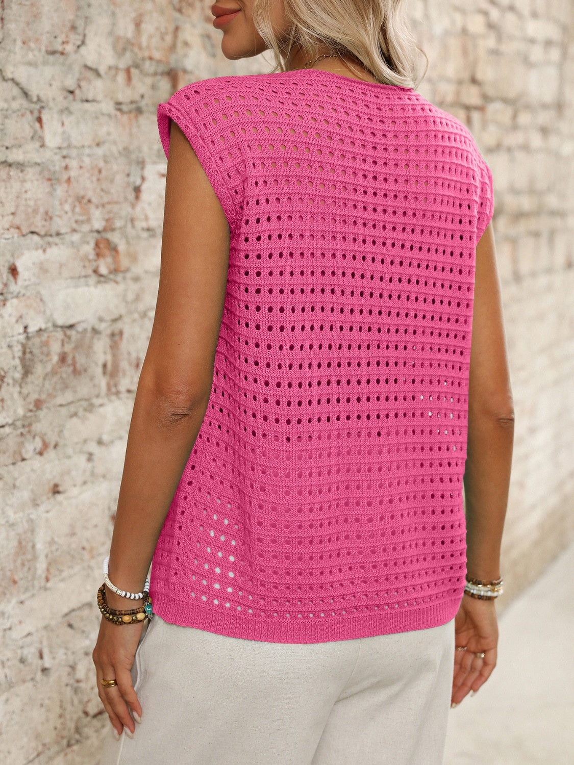 Fuchsia pink open-knit sleeveless cardigan with a relaxed fit and textured pattern.