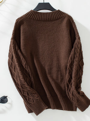 Chocolate cable knit sweater with ribbed crew neck and textured sleeves.