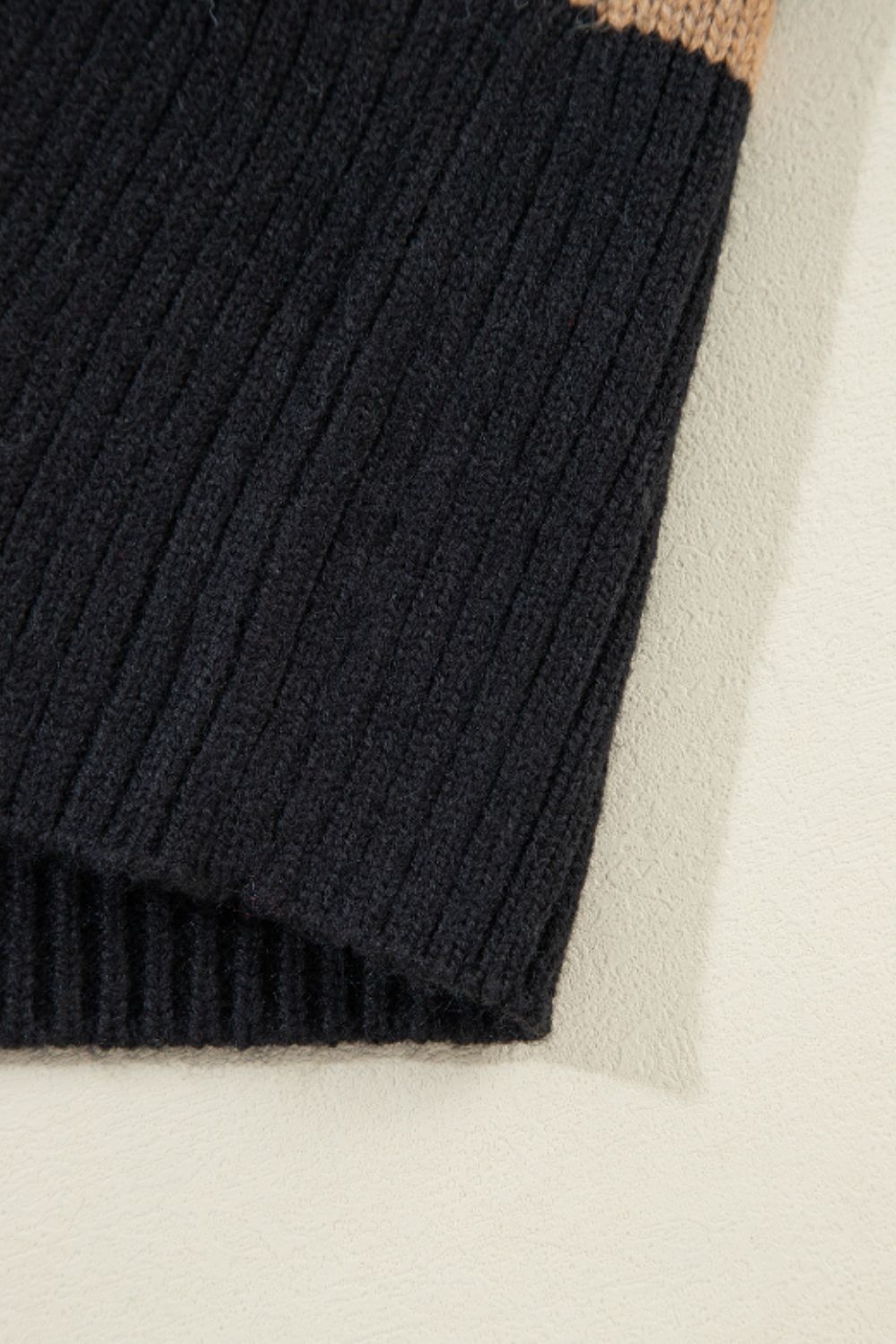 Chunky knit black cardigan with a tan stripe detail.