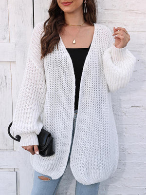White open knit cardigan with balloon sleeves and ribbed cuffs, styled with a black top.