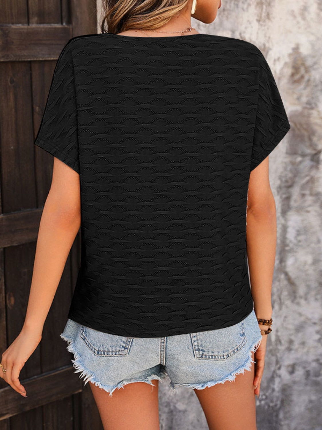 Black cap-sleeve blouse with textured wave pattern