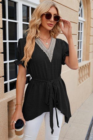 Black dotted swiss blouse with lace trim V-neck, short sleeves, tie waist and asymmetric hem.
