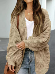 Chunky knit cocoon cardigan in tan with balloon sleeves and an open front, styled with a white top and jeans.