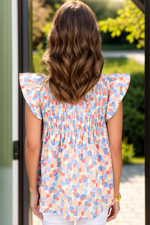 Smocked bodice blouse with flutter sleeves in a brushstroke print, featuring pastel blue, sherbet, and teal hues.